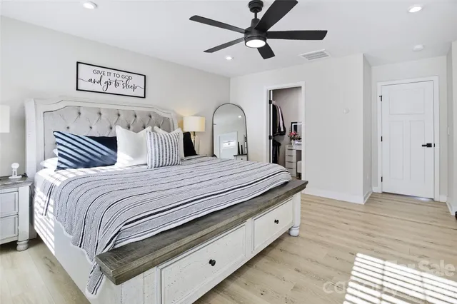 a bedroom with a large bed and a chandelier