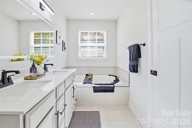 a bathroom with a sink a tub and a window