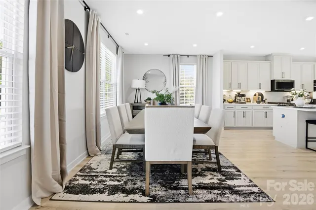 a living room with stainless steel appliances furniture a rug and a window