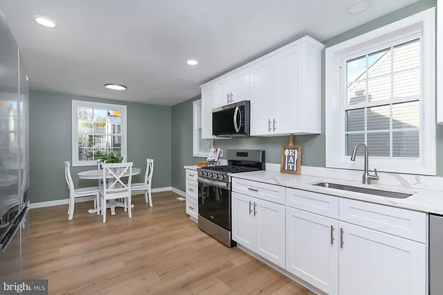 a kitchen with a dining table chairs and sink