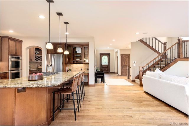 a dining hall with stainless steel appliances kitchen island granite countertop a living room view