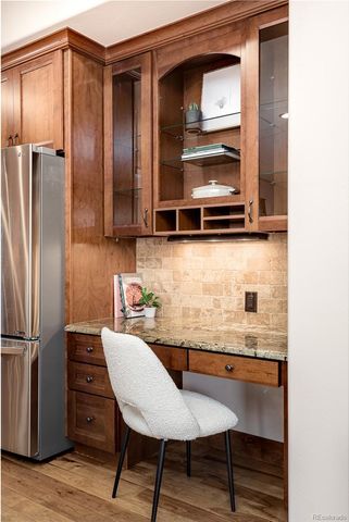 a kitchen with a refrigerator and wooden cabinets