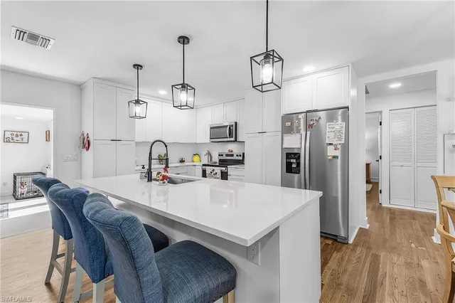 a kitchen with refrigerator cabinets and wooden floor