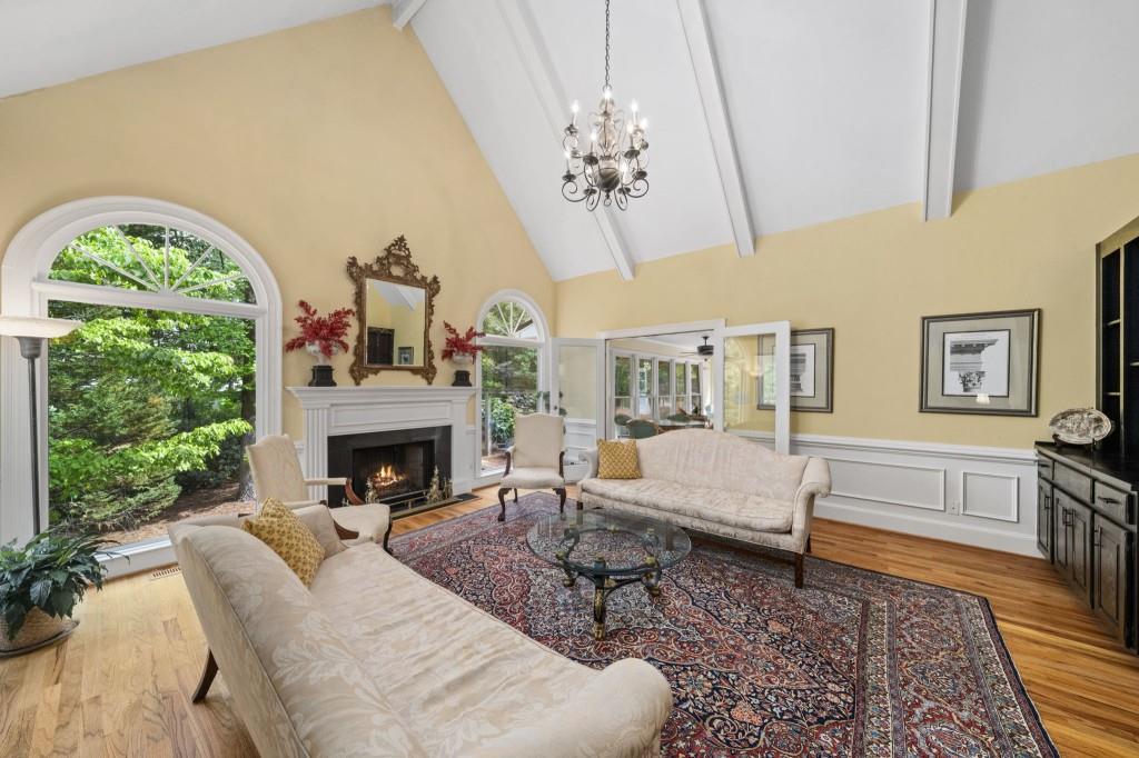 300 Waterpine Court Sandy Springs, GA 30350 - Photo 10 of 53 a living room with furniture a chandelier and a fireplace