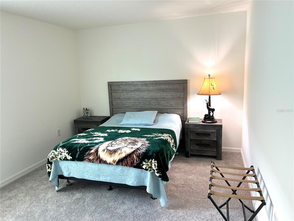 851 Alminar Avenue Southeast Palm Bay, FL 32909 - Photo 11 of 13 a bedroom with a bed and a lamp