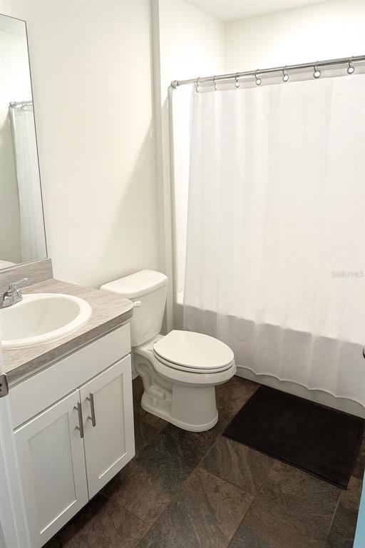 851 Alminar Avenue Southeast Palm Bay, FL 32909 - Photo 8 of 13 a bathroom with a toilet a sink and a mirror