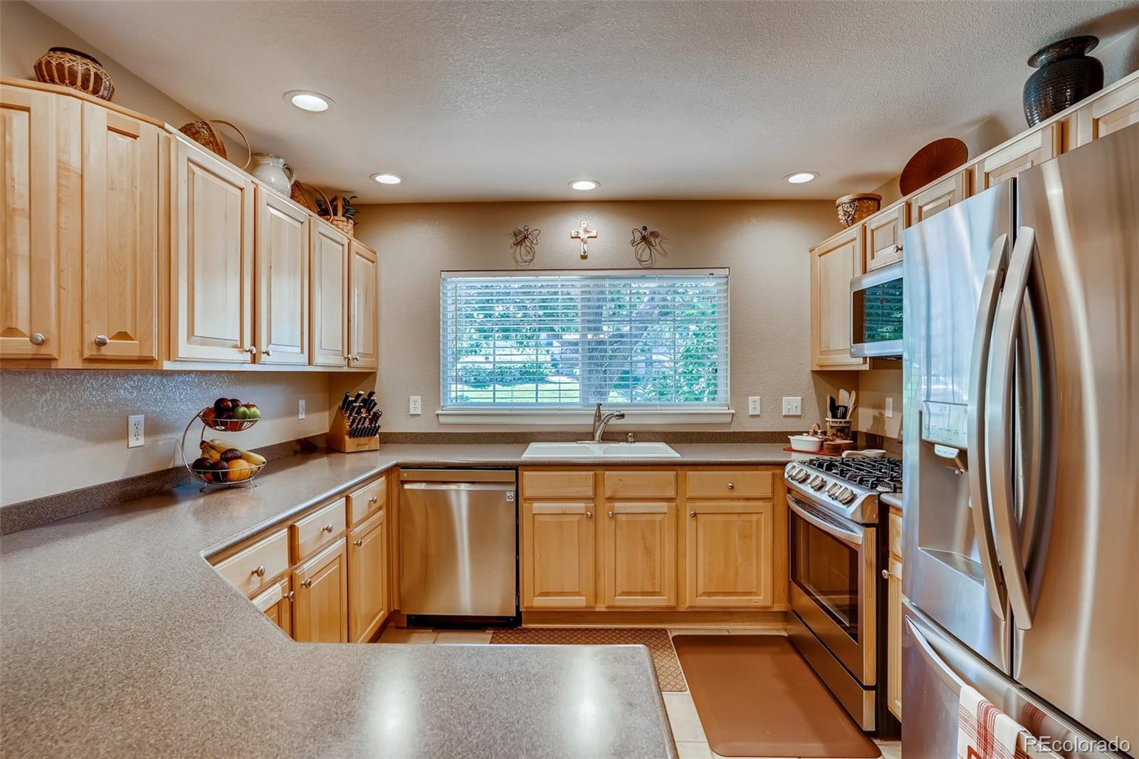 6123 Trailhead Road Highlands Ranch, CO 80130 - Photo 4 of 26 a kitchen with stainless steel appliances granite countertop a refrigerator and a sink
