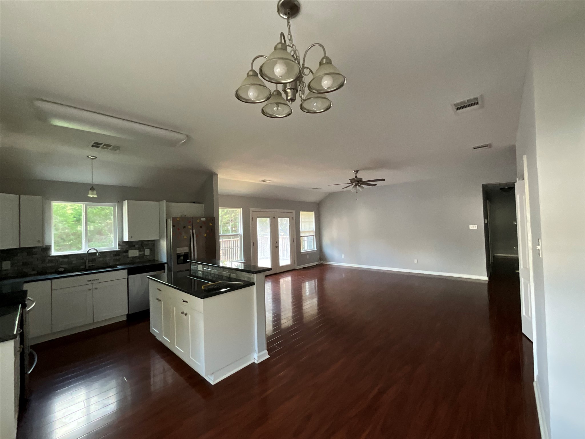 239 Old Firetower Road Bastrop, TX 78602 - Photo 28 of 39 Kitchen open to dining living with decorative light fixtures, white cabinets, ceiling fan, appliances with stainless steel finishes, and a kitchen island