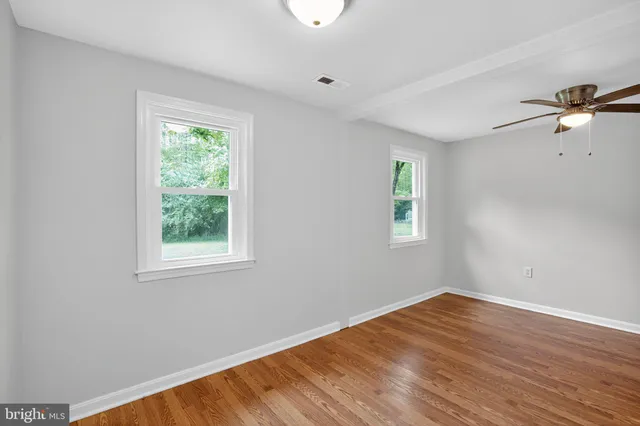 wooden floor in an empty room with a window
