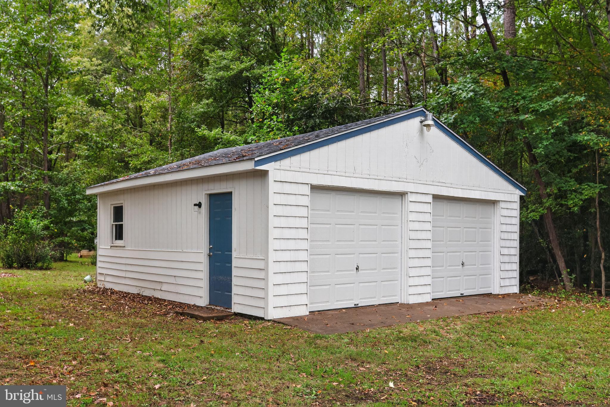 2895 Pomona Road Colonial Beach, VA 22443 - Photo 3 of 29 a view of a white house with a small yard and large tree