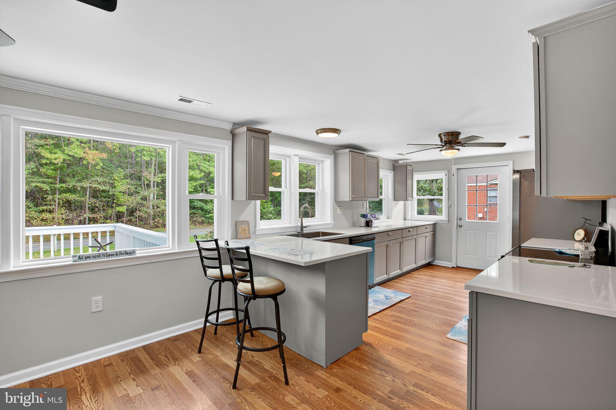 2895 Pomona Road Colonial Beach, VA 22443 - Photo 5 of 29 a kitchen with stainless steel appliances granite countertop sink stove and wooden floor