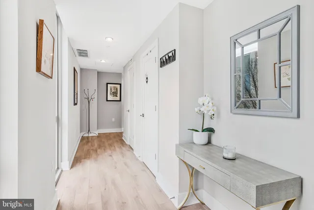 a view of hallway with sink and wooden floor