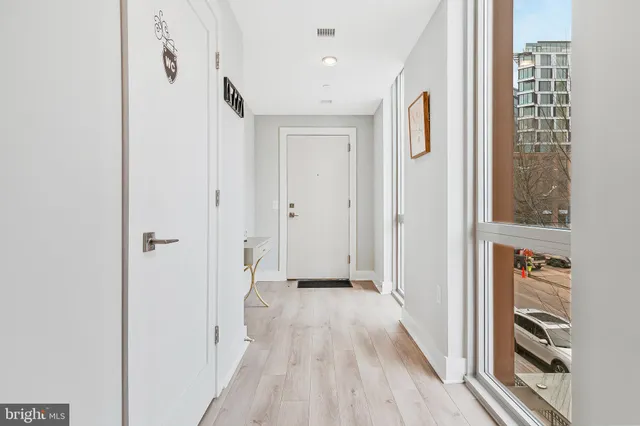 a view of a hallway with wooden floor and staircase