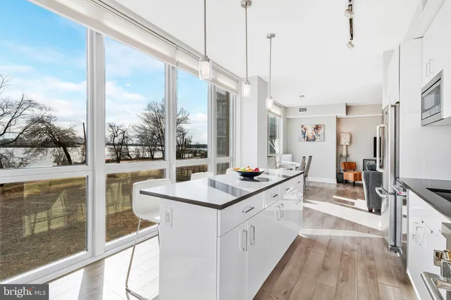 a kitchen with stainless steel appliances a sink a counter top space and a view of living room