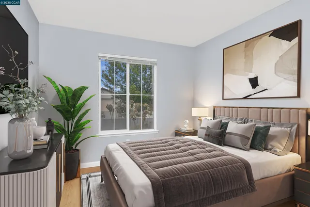 a bedroom with a large bed and a potted plant