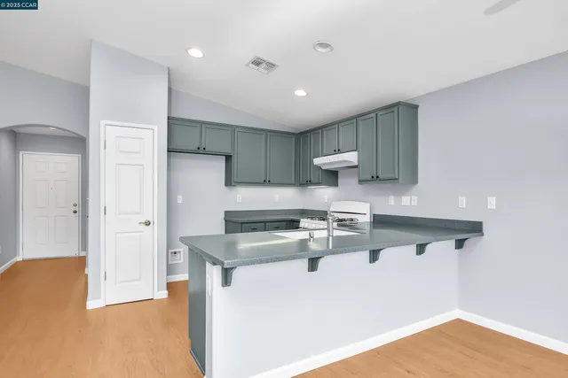 a kitchen with stainless steel appliances granite countertop a sink refrigerator and cabinets