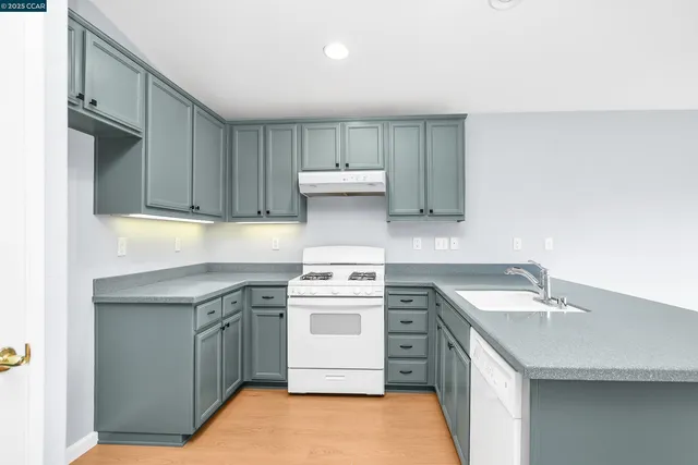 a kitchen with a sink stove and cabinets