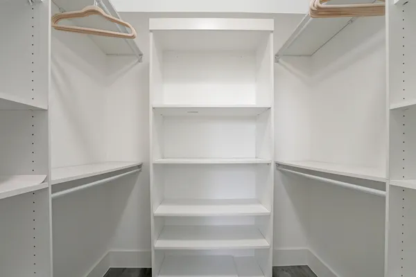 a view of walk in closet with empty racks