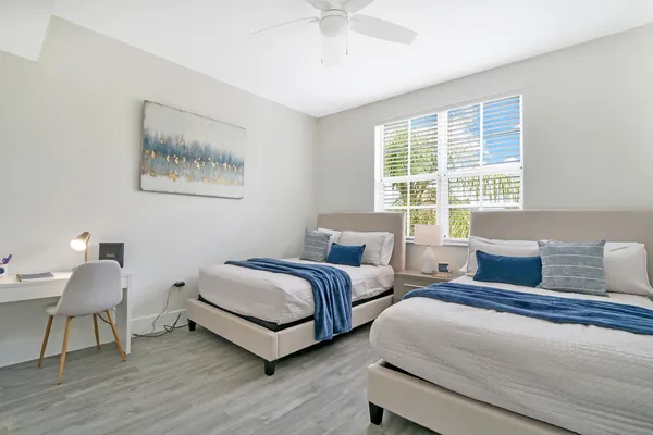 a spacious bedroom with two beds and a window