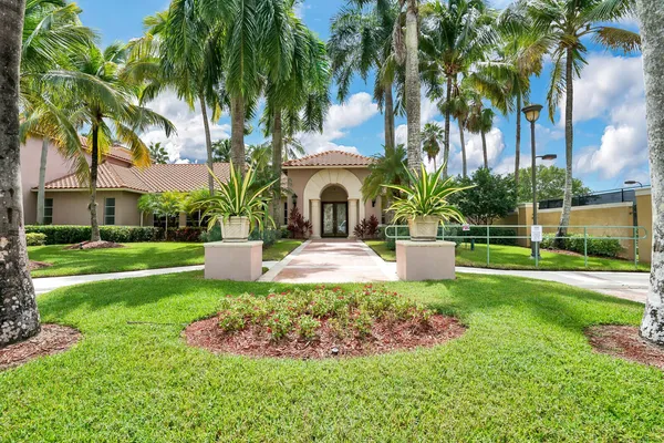 a view of a house with a yard and palm trees