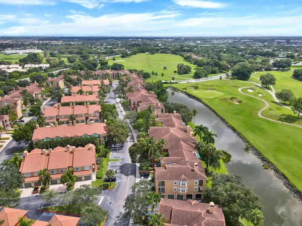 an aerial view of a city with lots of residential buildings ocean and mountain view in back