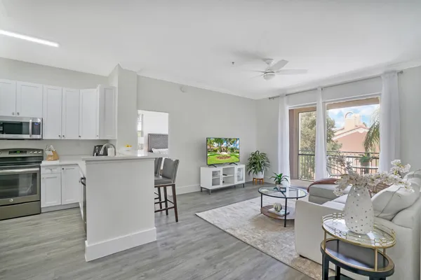 a living room with furniture and a open kitchen view