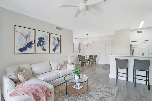 a living room with furniture a wooden floor and a painting on the wall