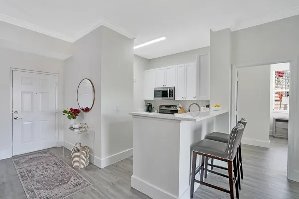 a kitchen with stainless steel appliances granite countertop a stove a refrigerator and a dining table with wooden floor