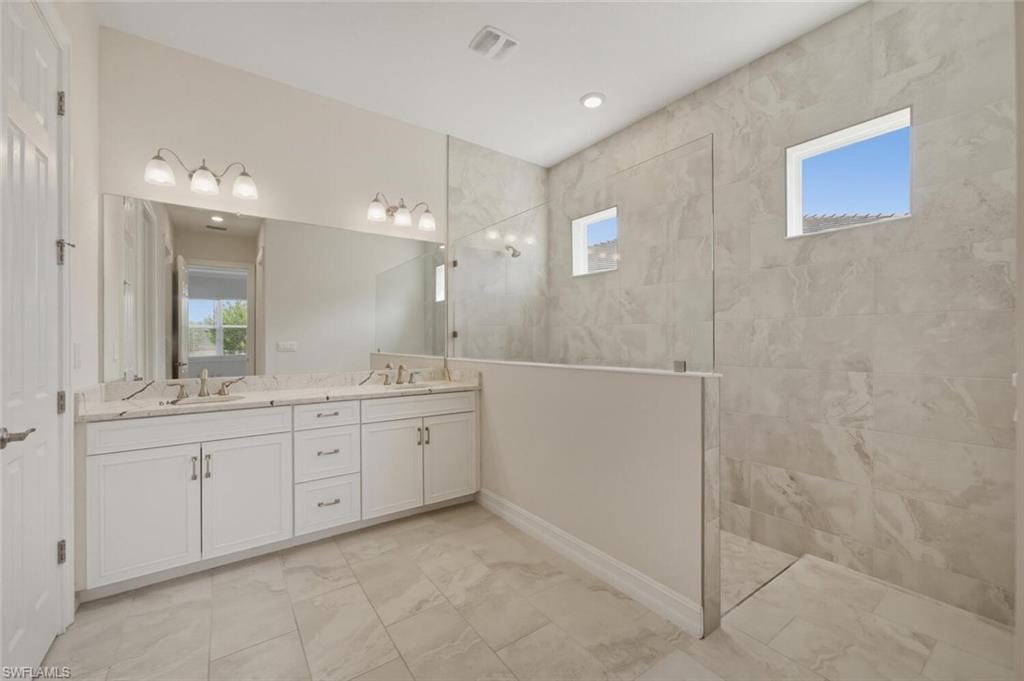 28053 Captiva Shell Loop Bonita Springs, FL 34135 - Photo 18 of 50 a bathroom with a granite countertop sink a mirror and a bathtub