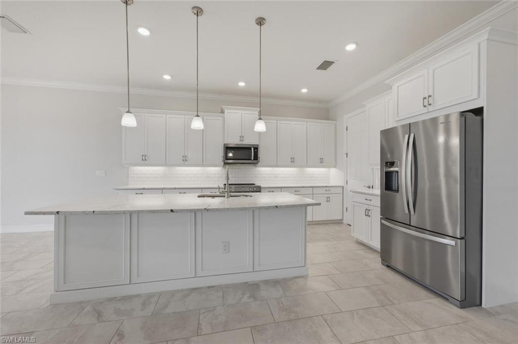 28053 Captiva Shell Loop Bonita Springs, FL 34135 - Photo 8 of 50 a kitchen with kitchen island a sink stainless steel appliances and cabinets