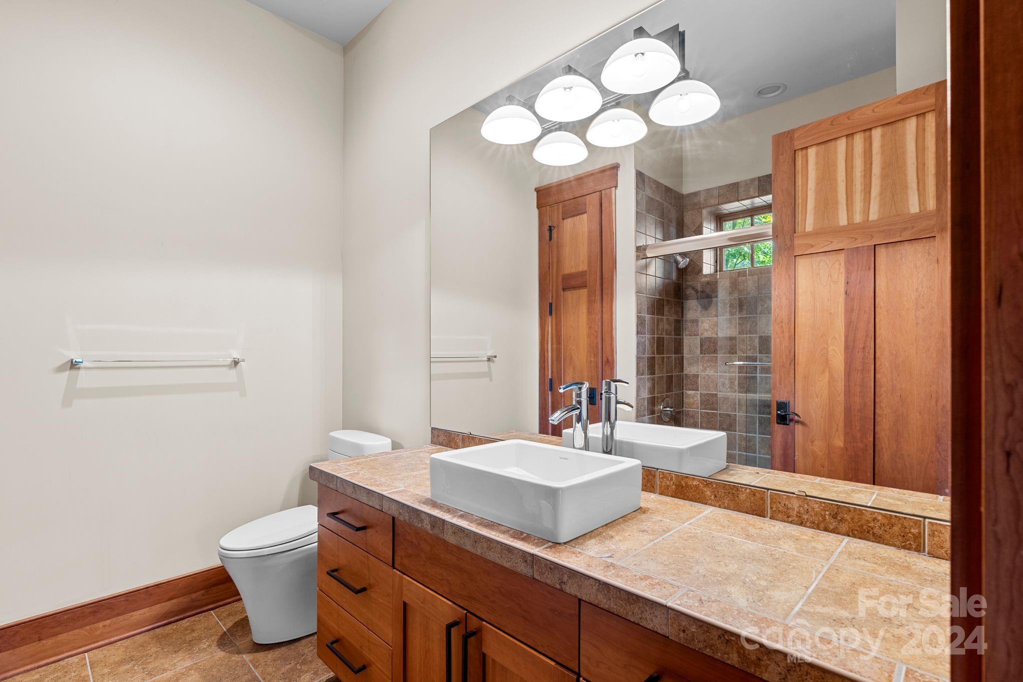 150 Cherry Hill Mill Spring, NC 28756 - Photo 25 of 39 a bathroom with a granite countertop sink a toilet and a mirror