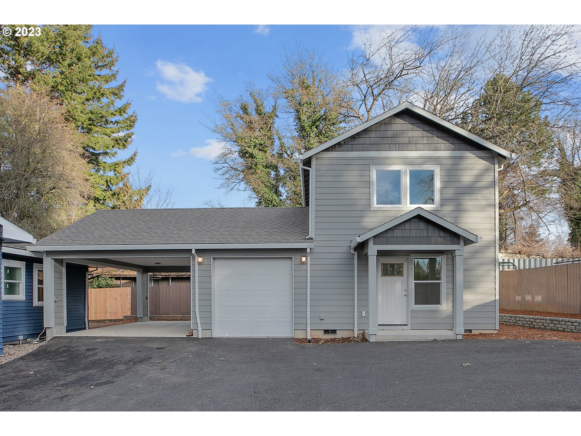 9046 Southeast Clinton Street, Unit B Portland, OR 97266 - Photo 2 of 18 a front view of a house with a yard and garage