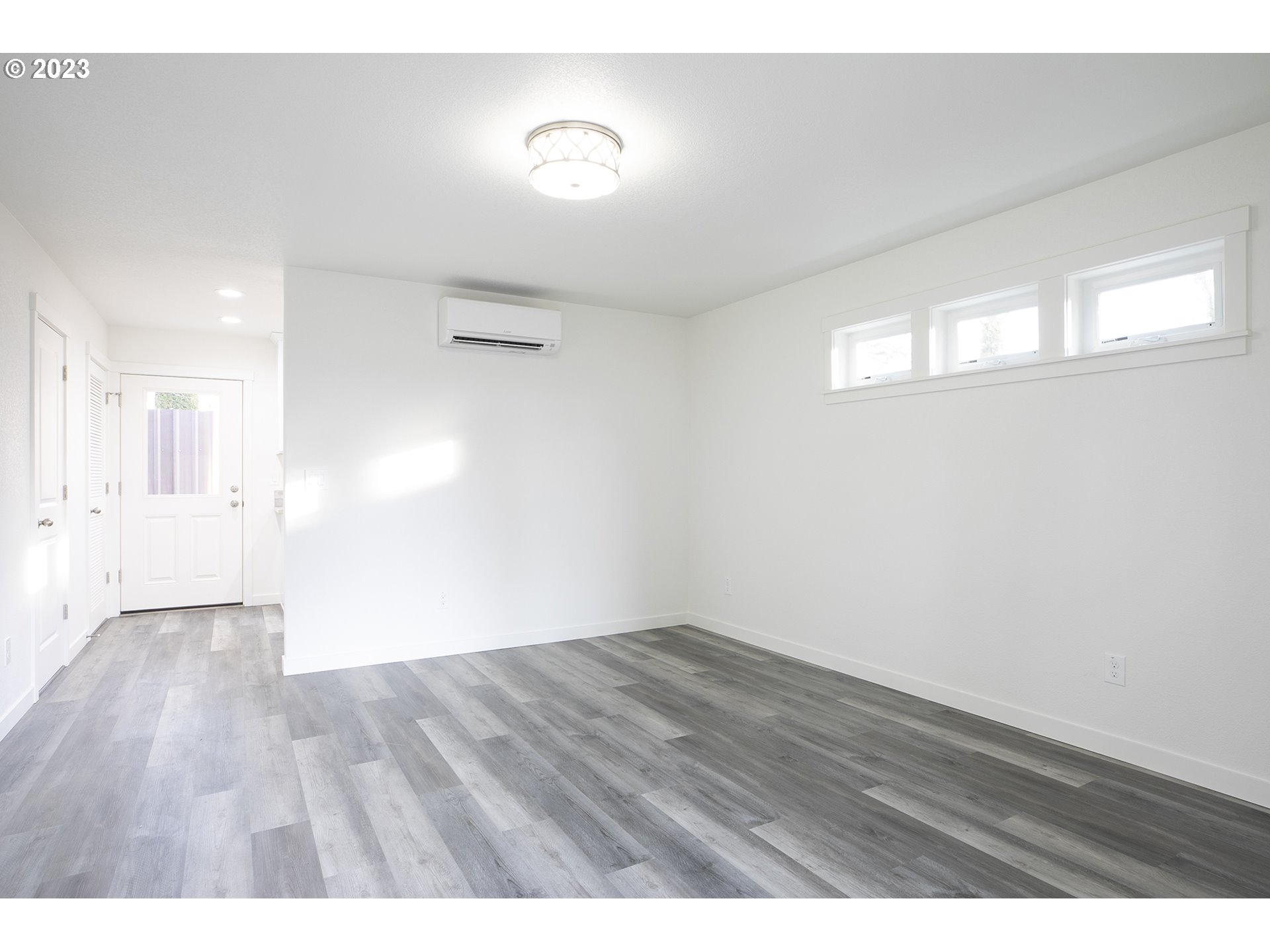9046 Southeast Clinton Street, Unit B Portland, OR 97266 - Photo 3 of 18 a view of an empty room with wooden floor
