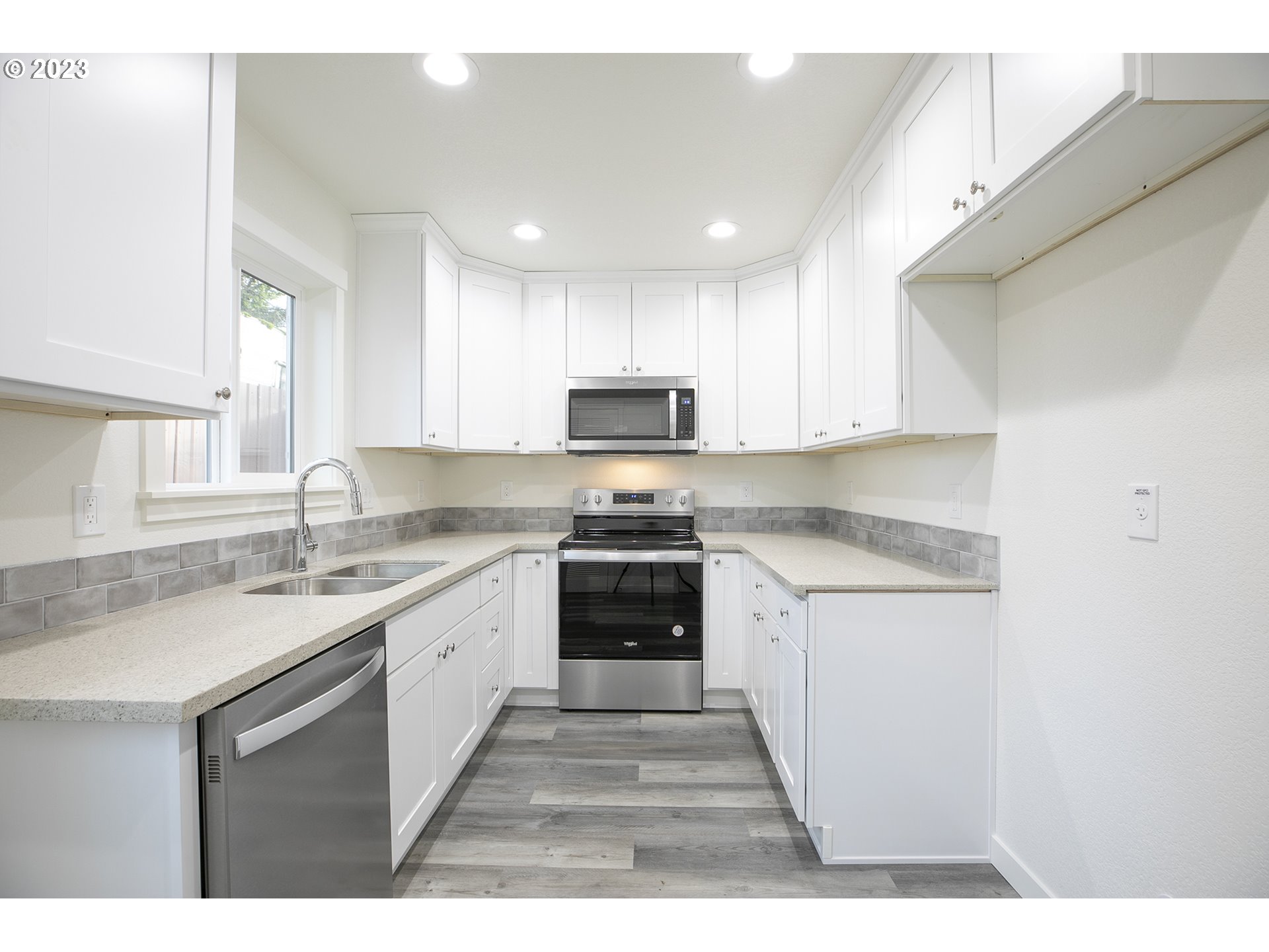 9046 Southeast Clinton Street, Unit B Portland, OR 97266 - Photo 8 of 18 a kitchen with a sink stove and microwave