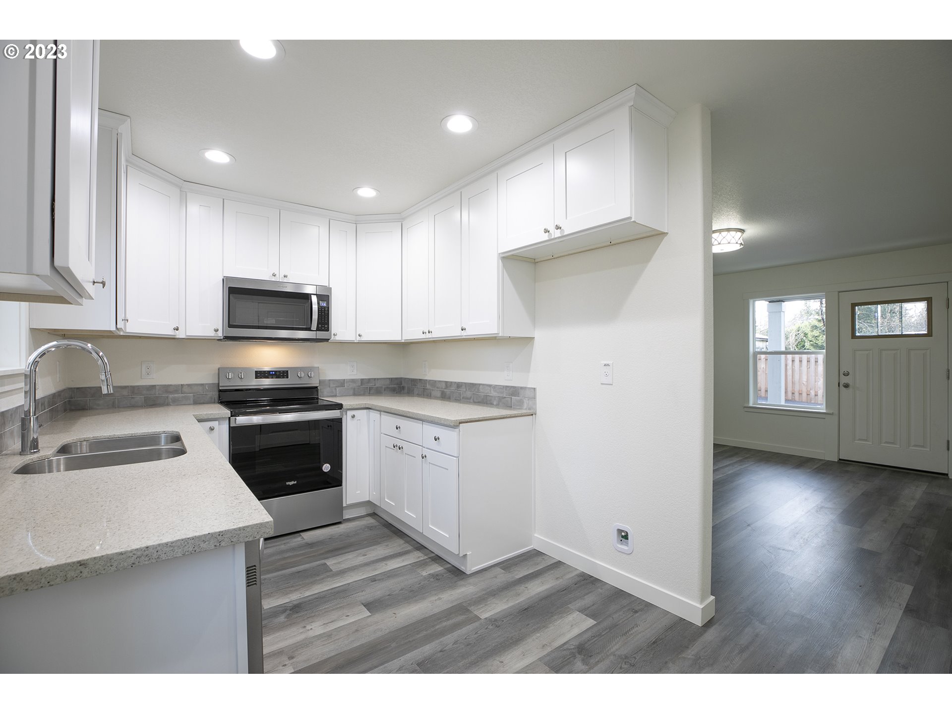 9046 Southeast Clinton Street, Unit B Portland, OR 97266 - Photo 9 of 18 a kitchen with granite countertop white cabinets and black stainless steel appliances