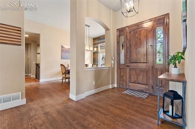 7880 Monarch Road Larkspur, CO 80118 - Photo 5 of 25 Entryway featuring a notable chandelier and dark wood-type flooring