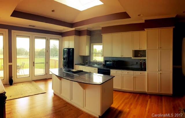 7503 Potter Road Waxhaw, NC 28173 - Photo 3 of 18 a kitchen with stainless steel appliances granite countertop a stove a sink and a microwave