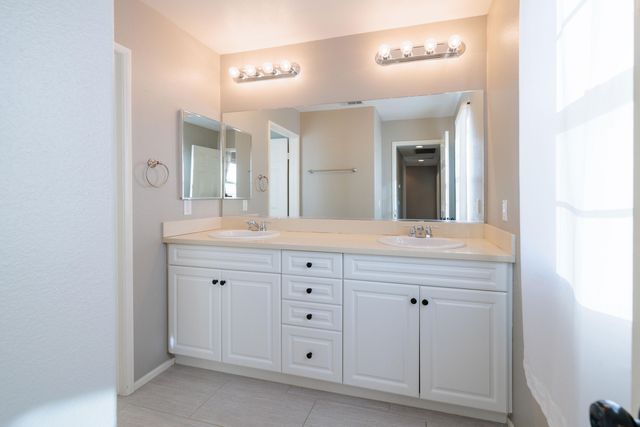 a bathroom with a double vanity sink and a mirror