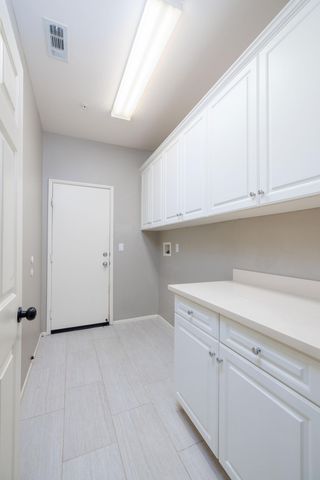a view of cabinets and utility room with closet