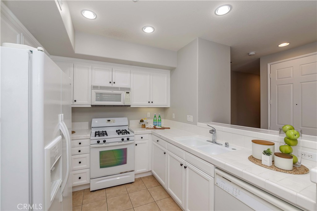 372 Quail Irvine, CA 92603 - Photo 6 of 22 a kitchen with white cabinets and white appliances