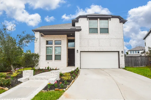 a front view of a house with a yard and garage