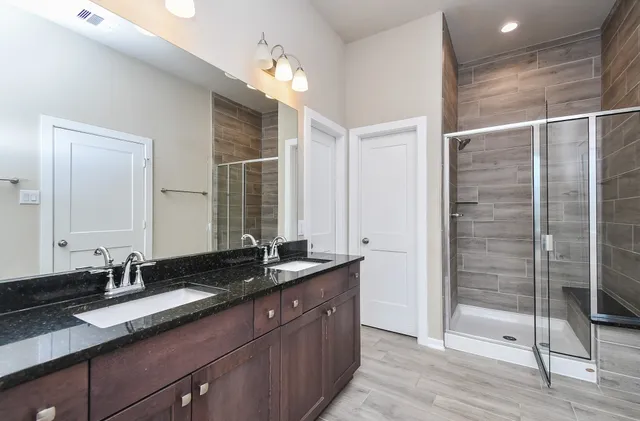 a bathroom with double vanity sinks and a mirror