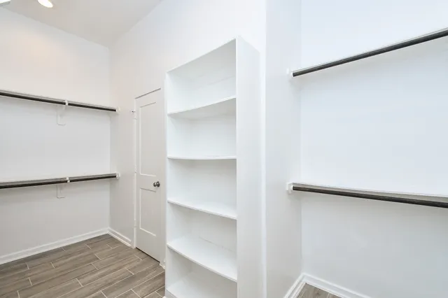 a view of walk in closet with empty racks