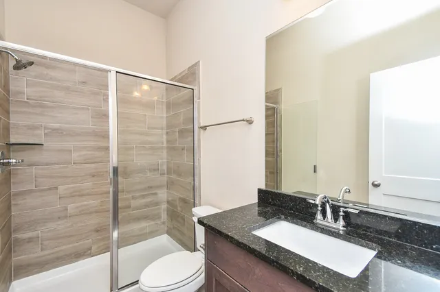 a bathroom with a granite countertop sink toilet and shower