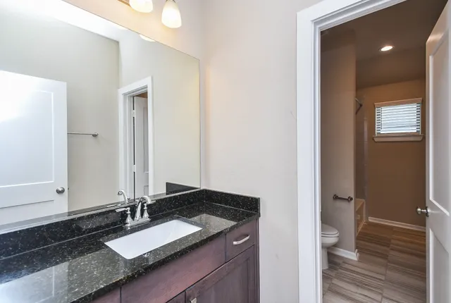 a bathroom with a granite countertop sink and a mirror