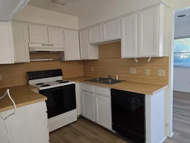a kitchen with cabinets appliances and a sink