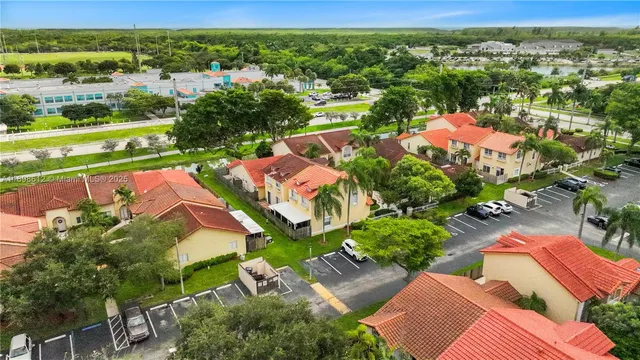 an aerial view of a city with lots of residential buildings ocean and mountain view in back