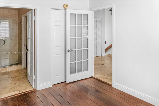 an empty room with wooden floor & windows