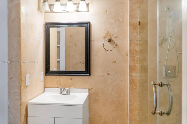 a bathroom with a sink a mirror a vanity and shower
