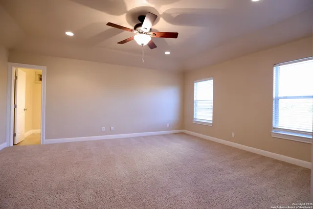 an empty room with a window and a fan